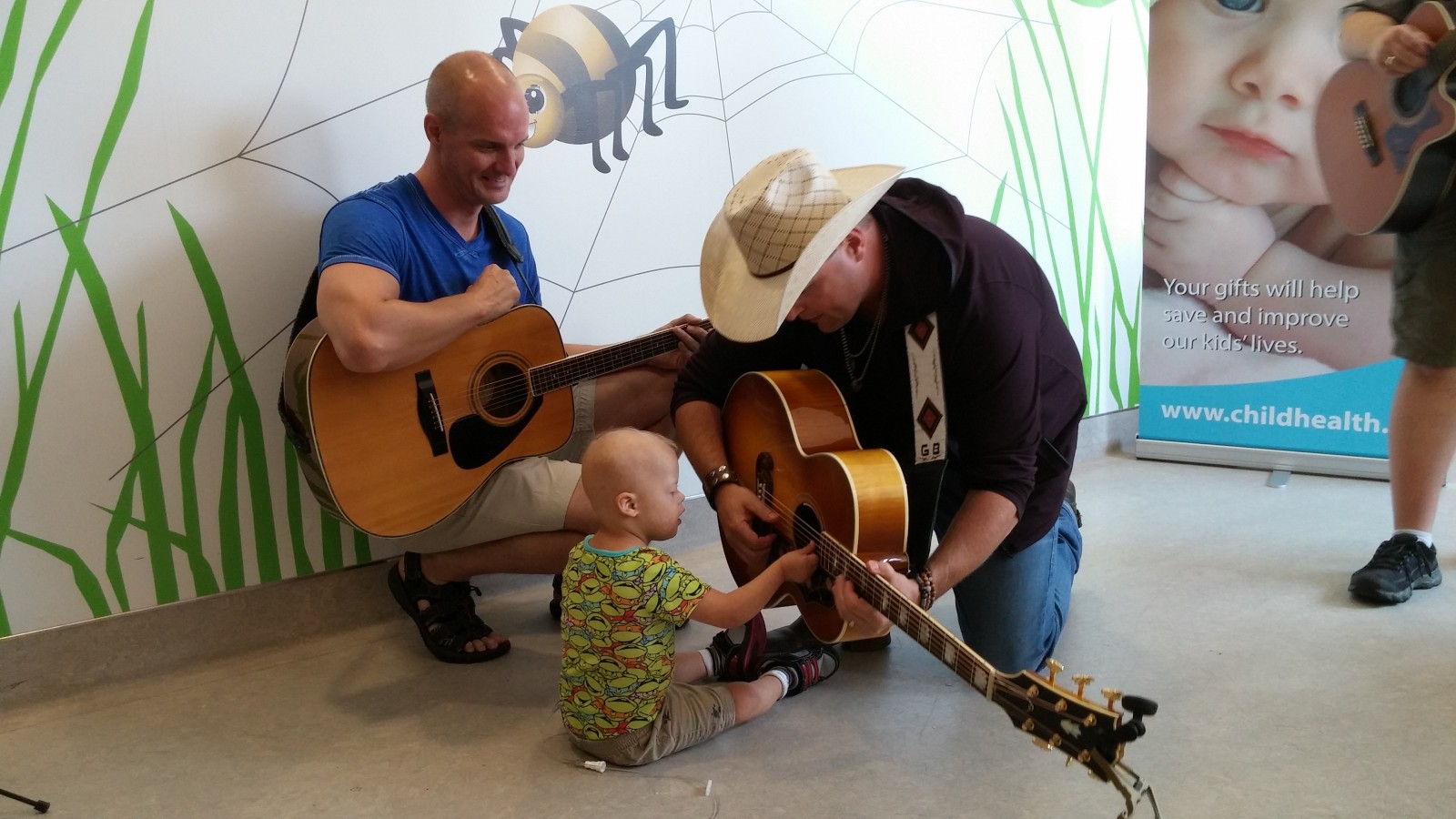 Young patient of the LHSC takes a special interest in Bamford's guitar.